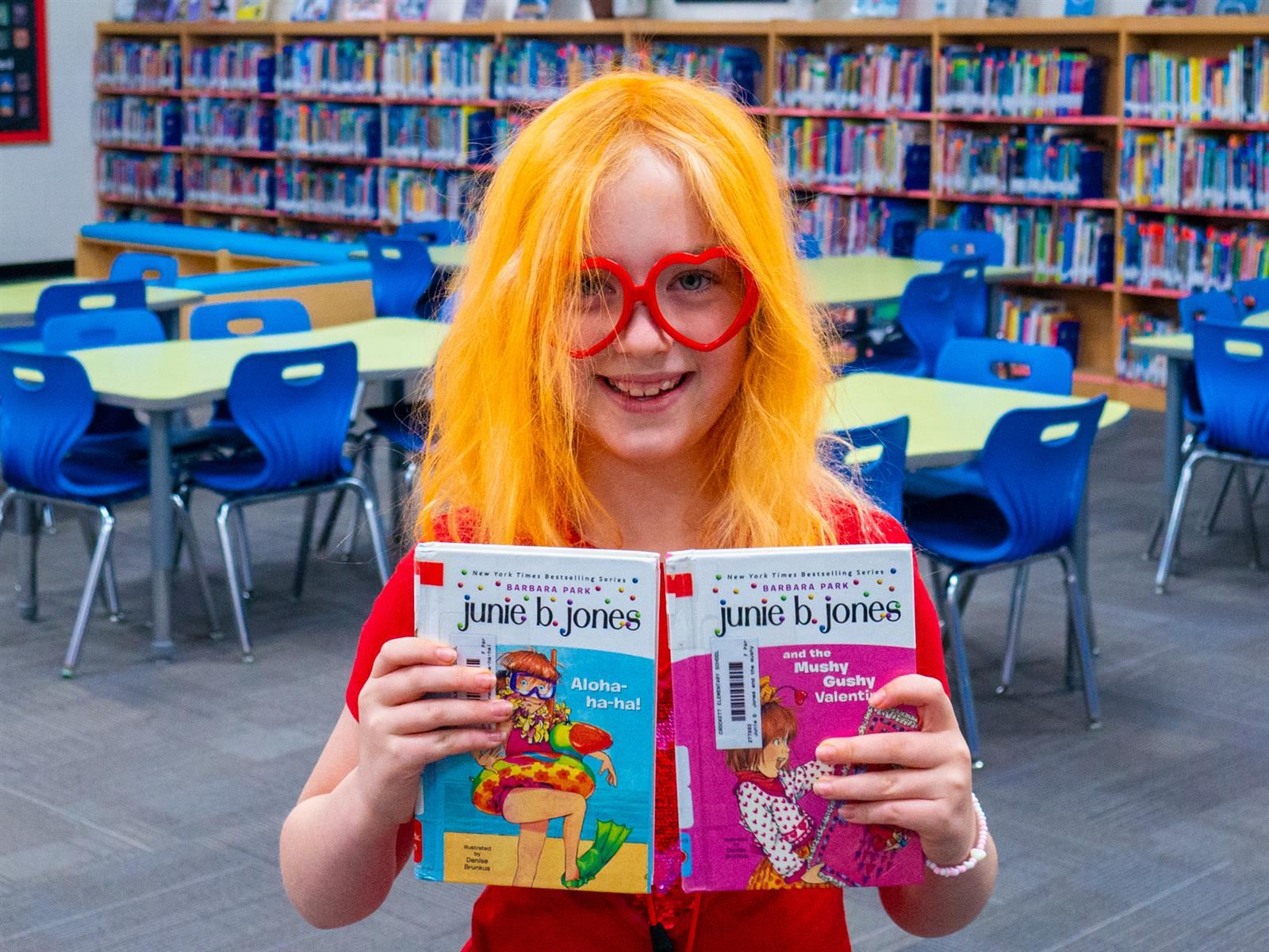 girl holding up books